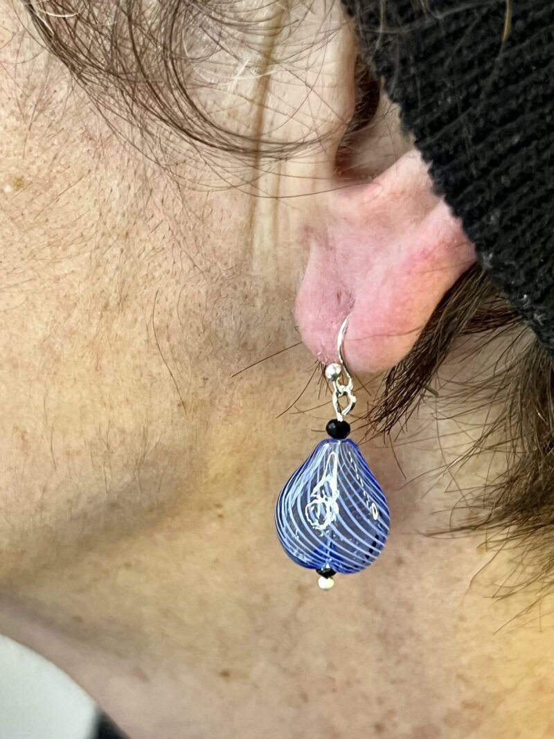 Øreringe med mundblæst glas perle i dråbe form i lys blå med hvide striber. Vælg i mellem forgyldt / forsølvet, eller Sterling sølv / forgyldt.