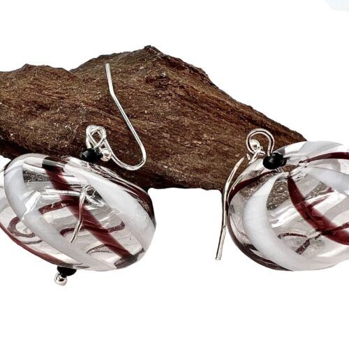 Øreringe med mundblæst glas perle i donutform i klart glas med hvide og lilla striber. Vælg i mellem forgyldt / forsølvet, eller Sterling sølv / forgyldt. Længden er ca. 3.5cm. Prisen er for et par.
