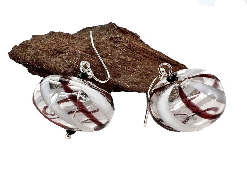Øreringe med mundblæst glas perle i donutform i klart glas med hvide og lilla striber. Vælg i mellem forgyldt / forsølvet, eller Sterling sølv / forgyldt. Længden er ca. 3.5cm. Prisen er for et par.